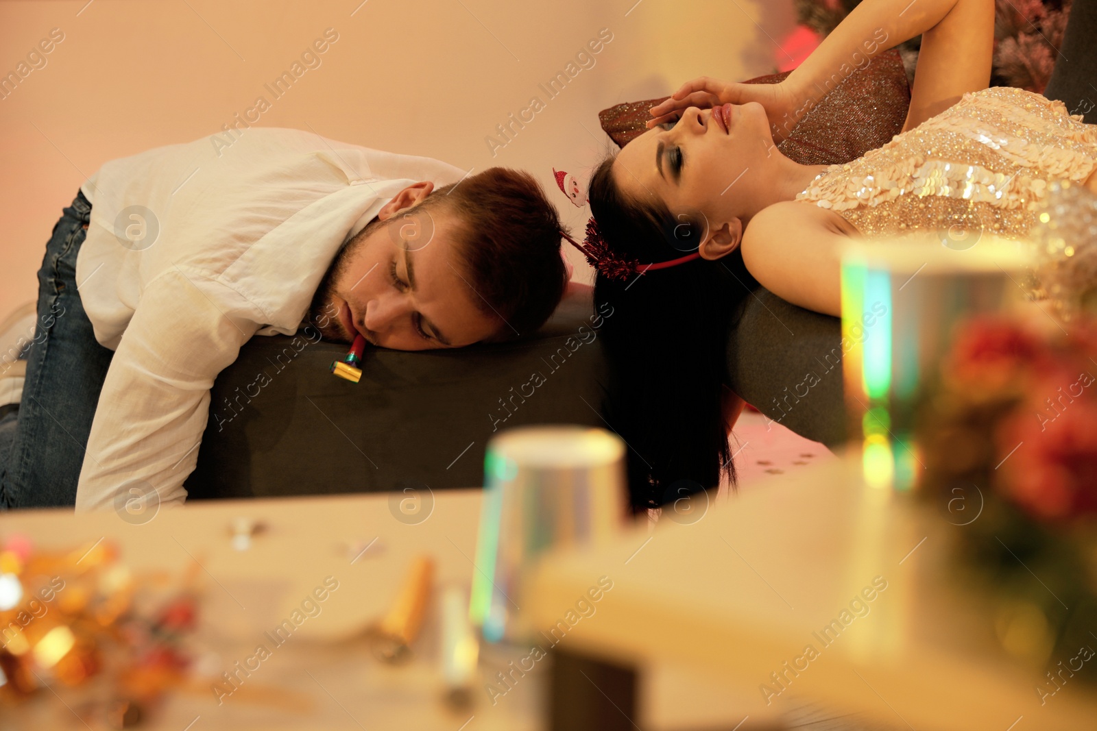 Photo of Drunk couple sleeping in messy room after New Year party