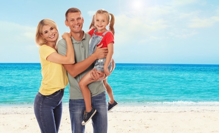 Happy family on sandy beach near sea. Summer vacation