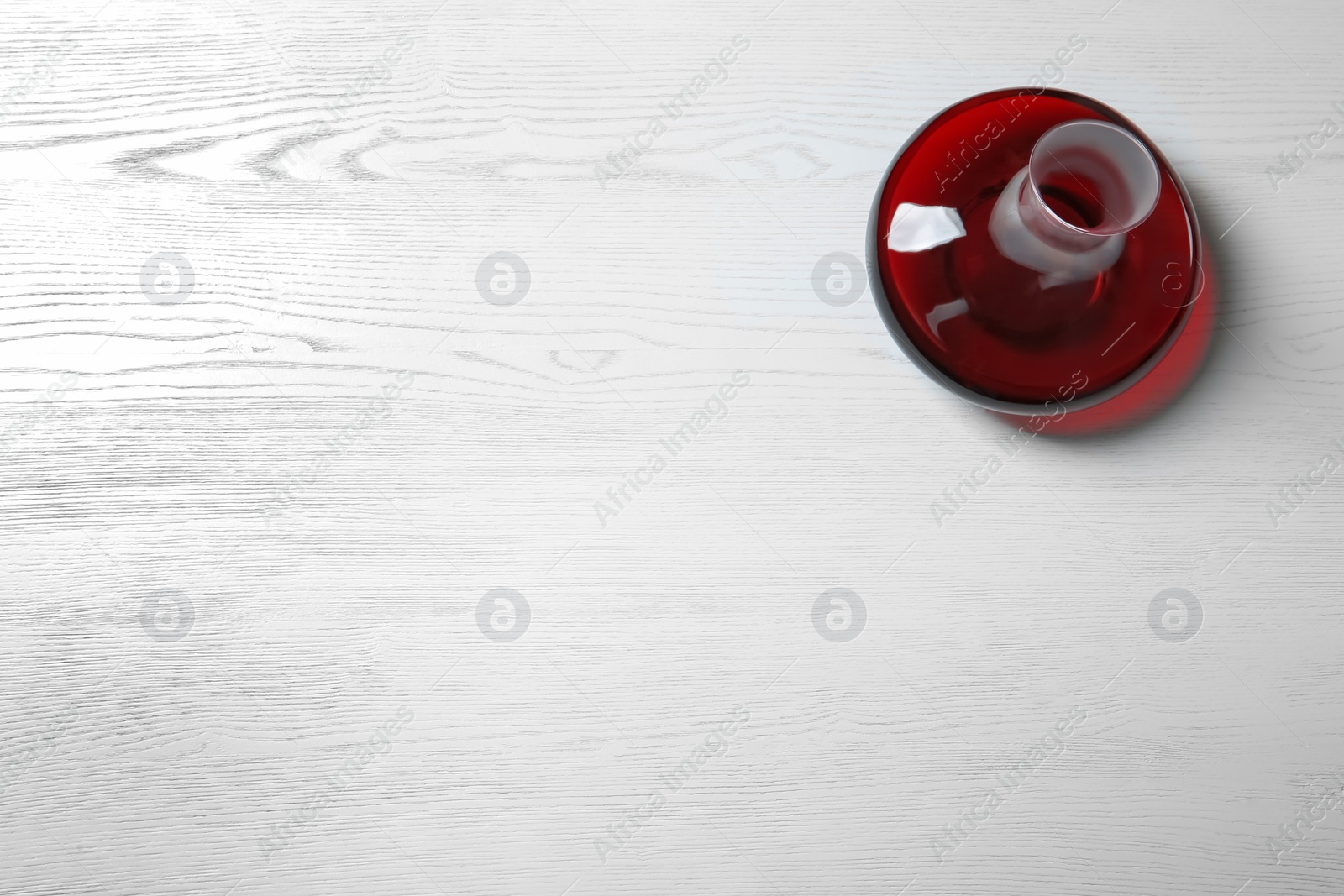 Photo of Decanter with red wine on wooden background, top view