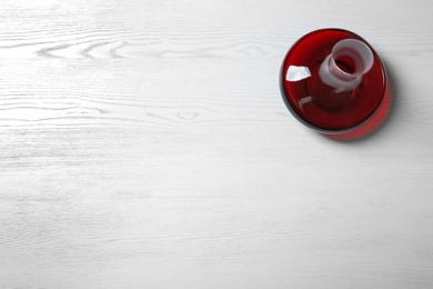 Decanter with red wine on wooden background, top view