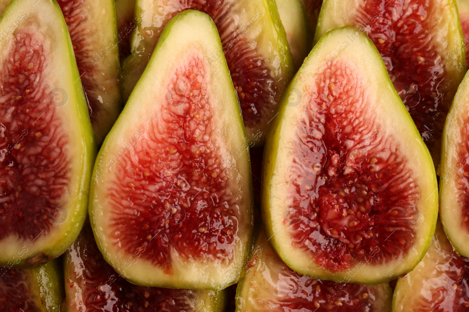 Photo of Pieces of fresh green figs as background, top view