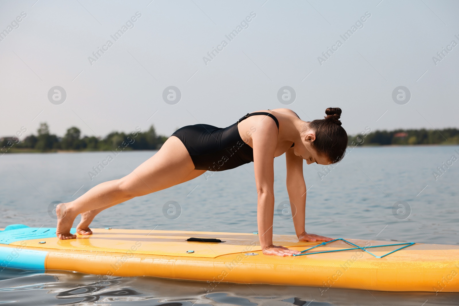 Photo of Woman practicing yoga on SUP board on river