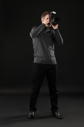 Professional photographer taking picture on black background