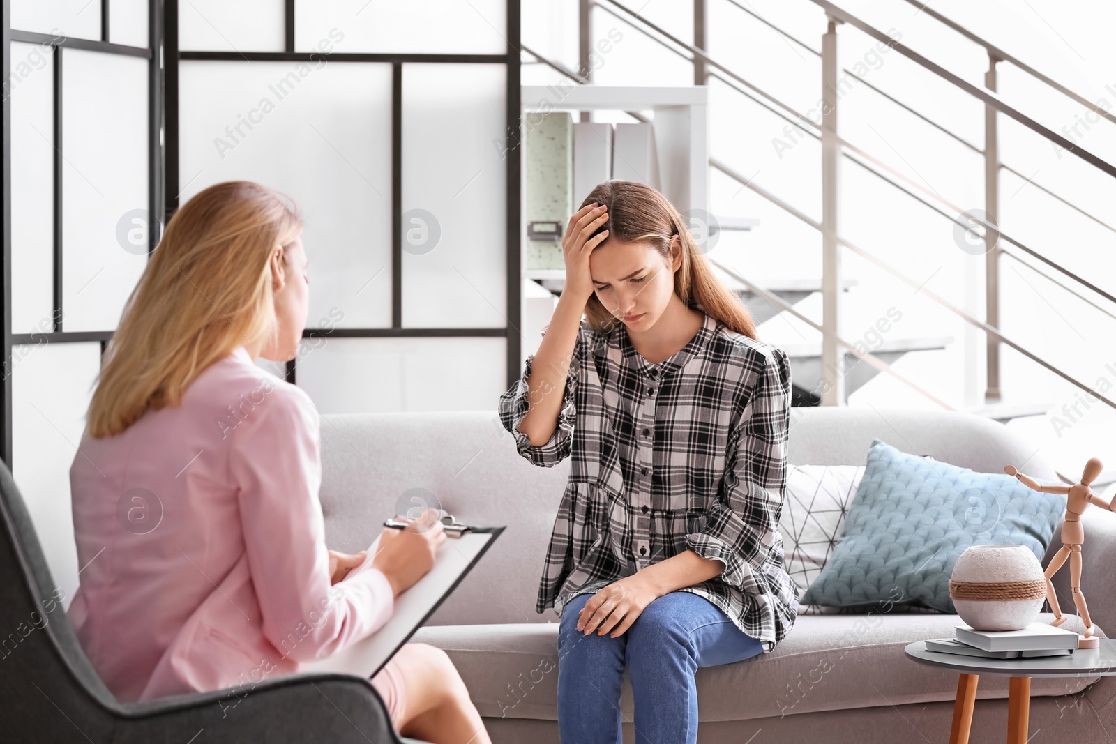 Photo of Child psychologist working with teenage girl in office