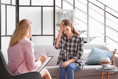 Child psychologist working with teenage girl in office