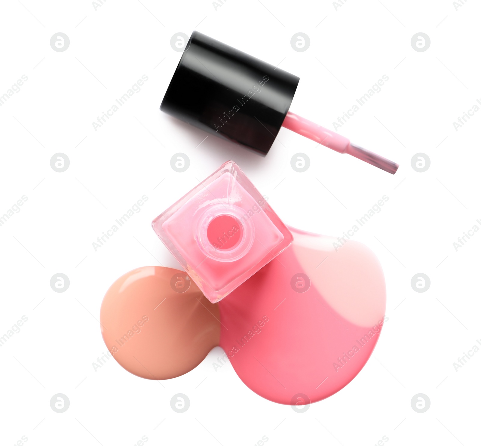 Photo of Spilled different nail polishes with bottle and brush on white background, top view