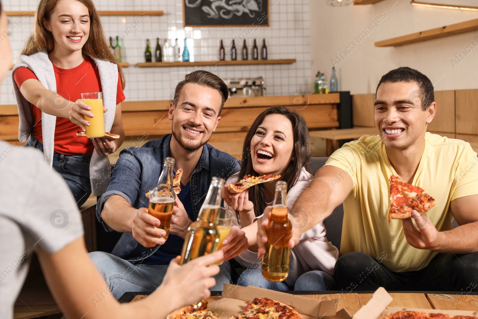 Photo of Group of friends having fun party with delicious pizza in cafe