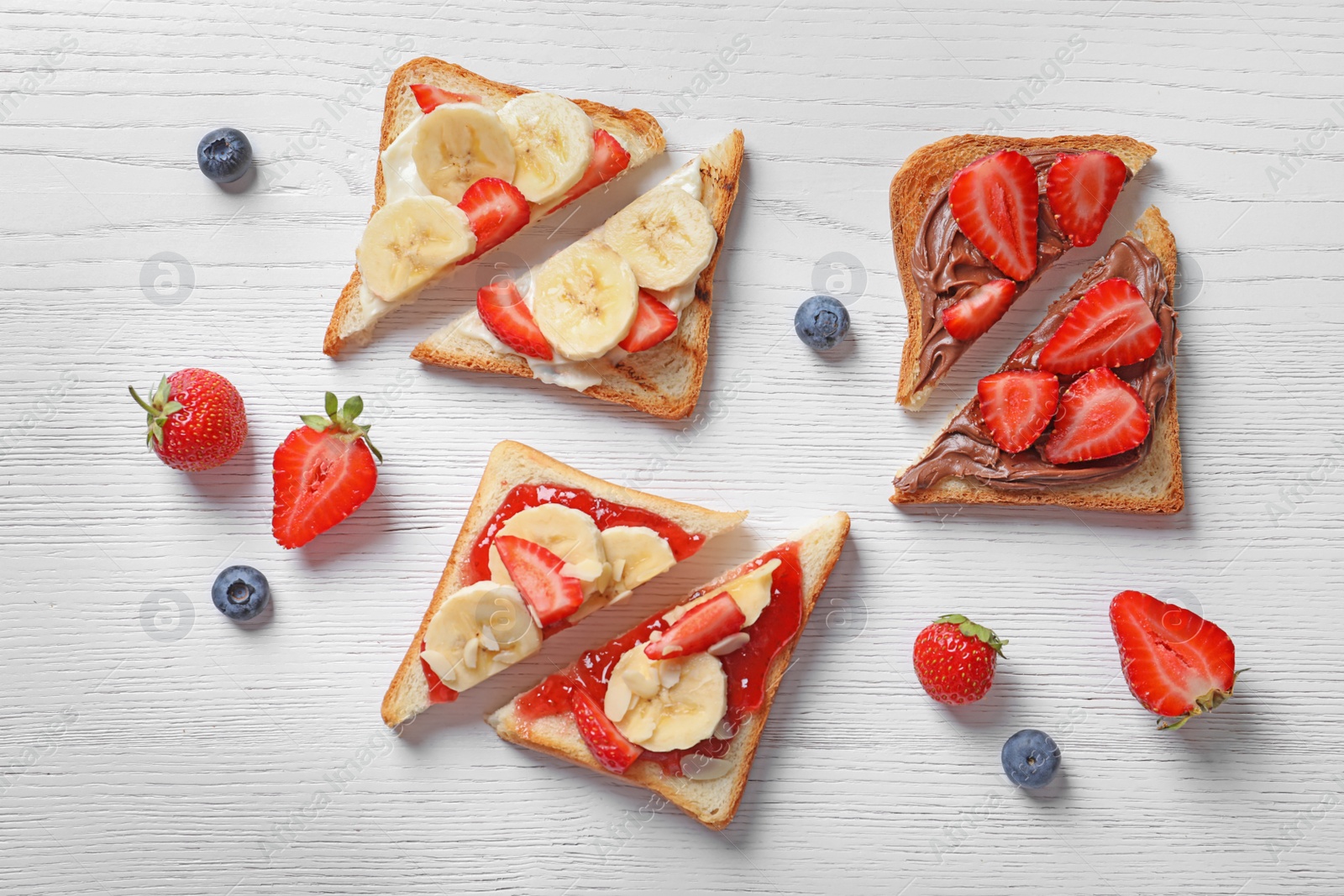 Photo of Tasty toast bread with banana and strawberry on light background