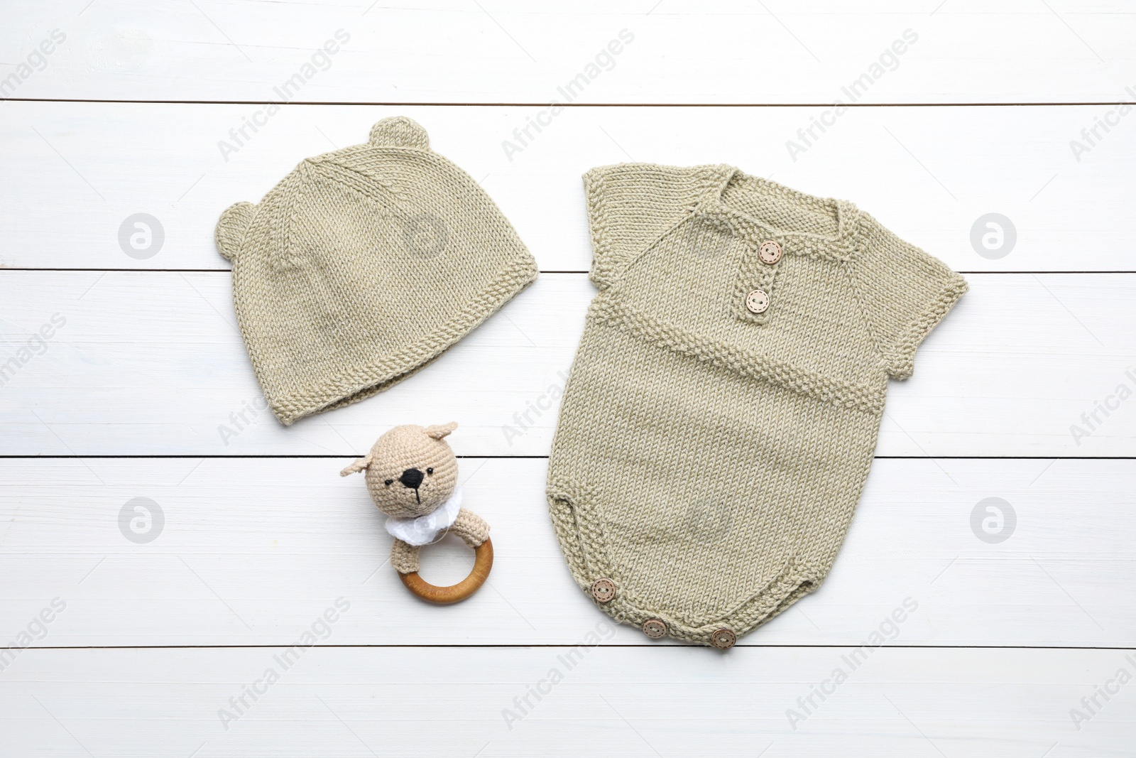 Photo of Flat lay composition with child's clothes and toy on white wooden table