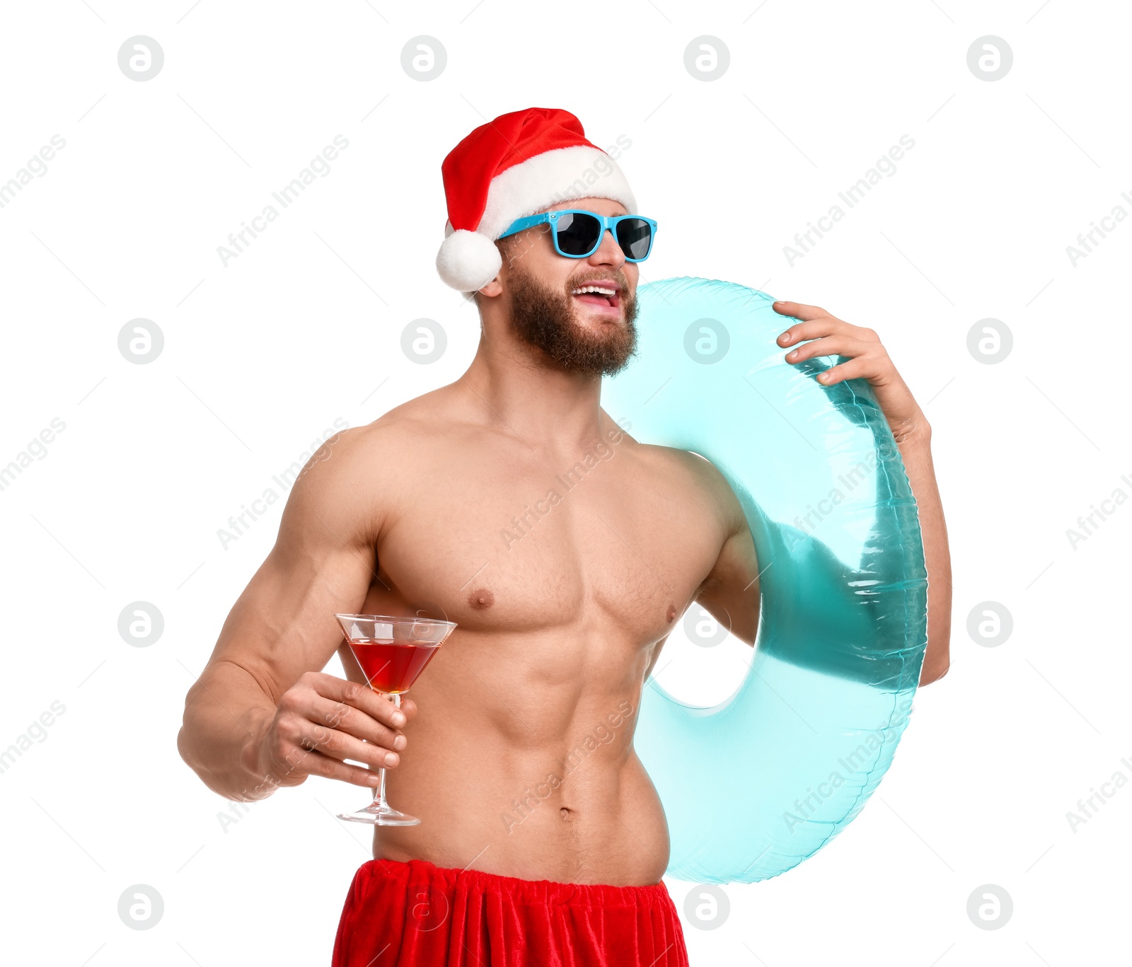 Photo of Muscular young man in Santa hat with inflatable ring and cocktail on white background