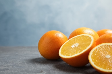 Photo of Fresh oranges on grey table. Space for text