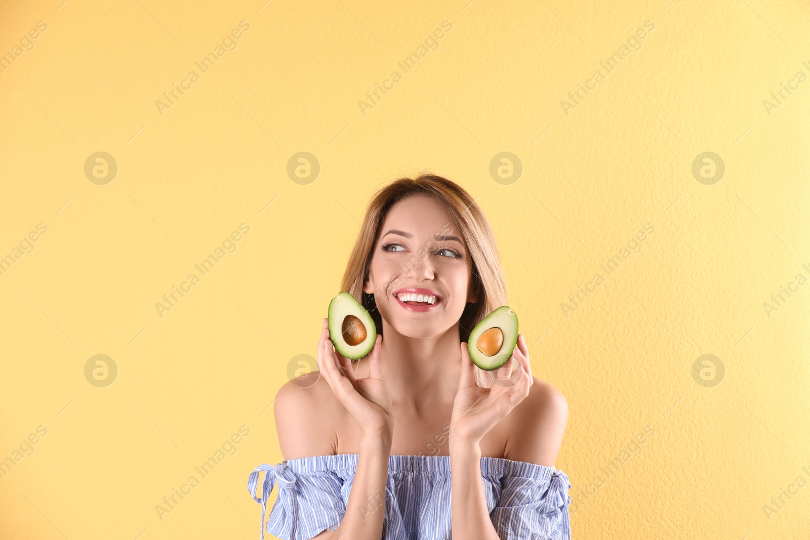 Photo of Portrait of young beautiful woman with ripe delicious avocado on color background