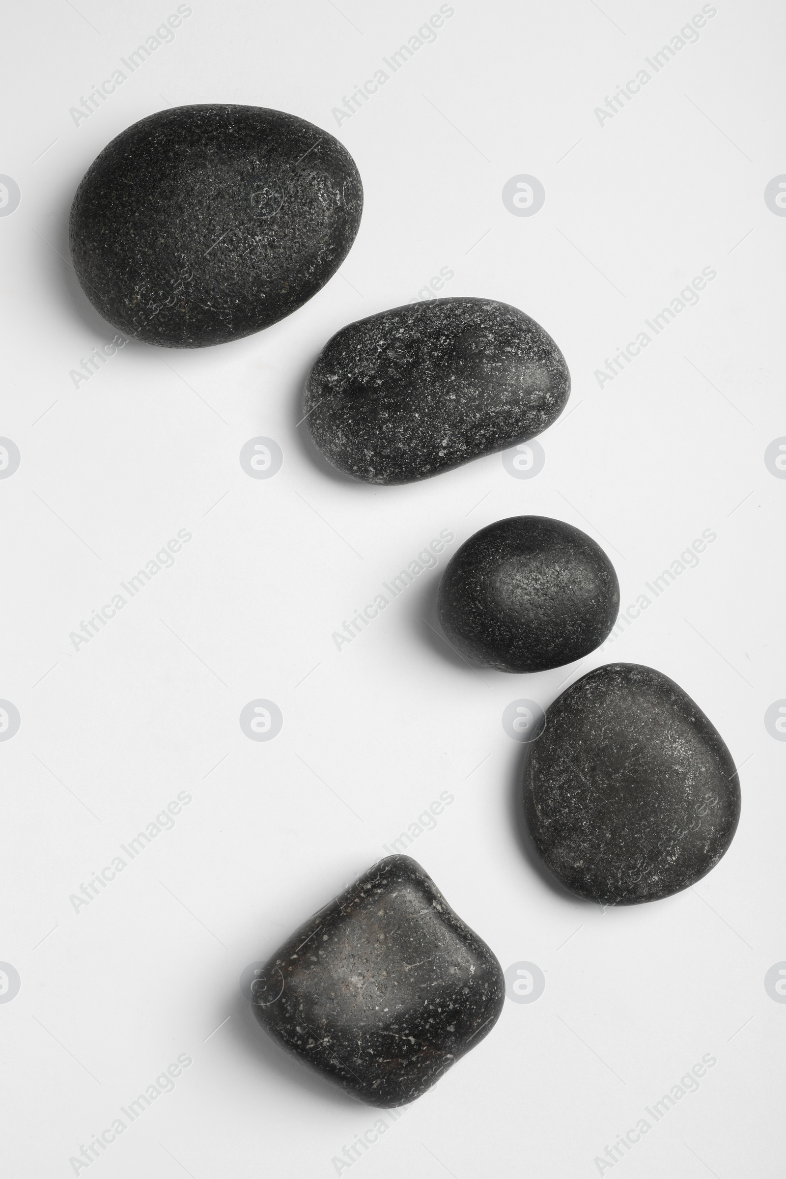 Photo of Many different stones on white background, top view