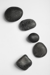 Photo of Many different stones on white background, top view