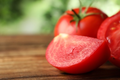 Photo of Fresh ripe tomatoes on wooden table, closeup. Space for text