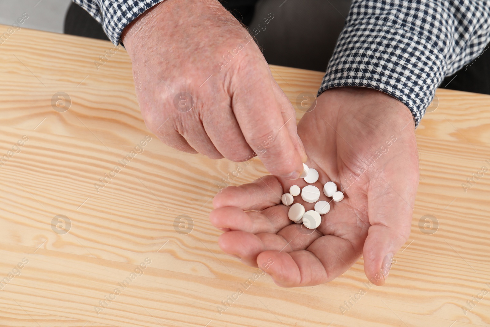 Photo of Senior man taking medicine at table, closeup. Health care