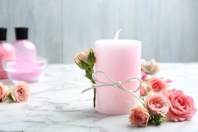 Photo of Candle with roses on marble table. Space for text