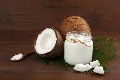 Photo of Composition with organic coconut oil on wooden table. Healthy cooking