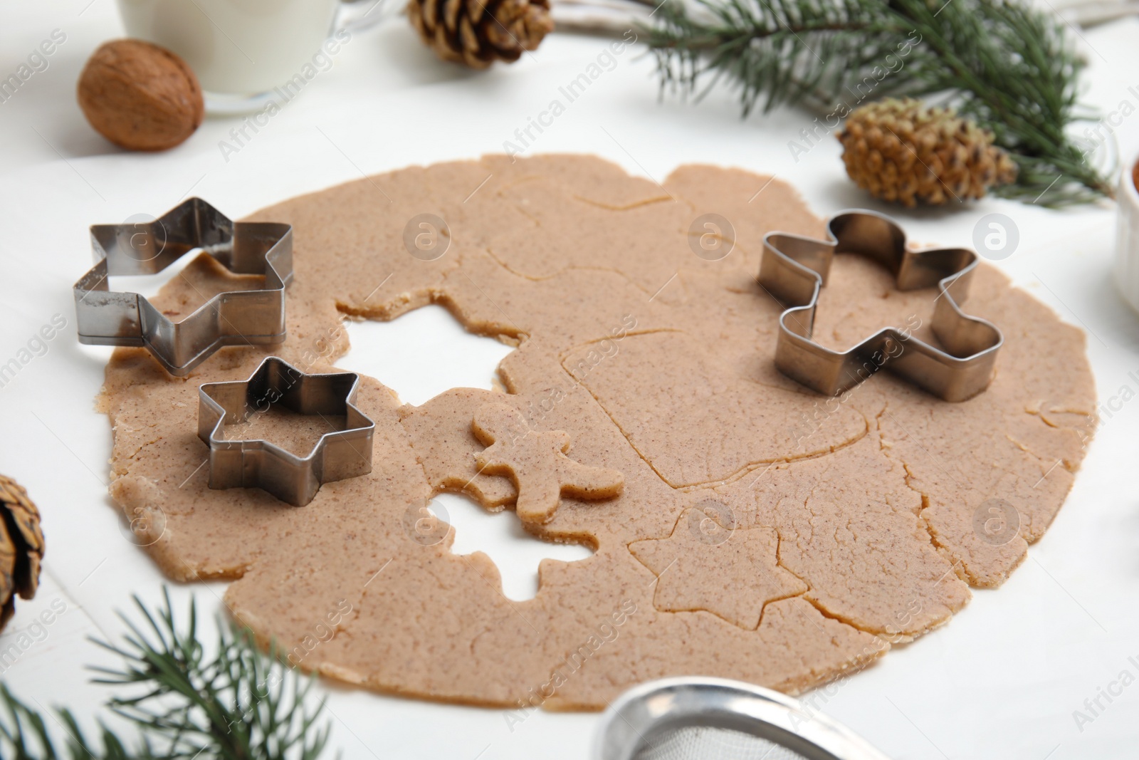Photo of Homemade Christmas biscuits. Raw dough and cookie cutters on white table