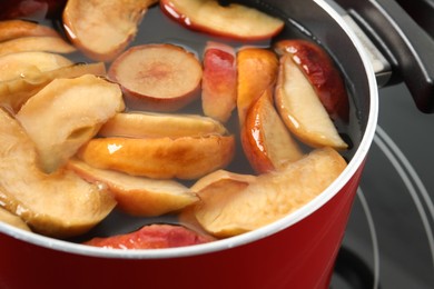 Pot of delicious compot with dried apple slices on stove, closeup