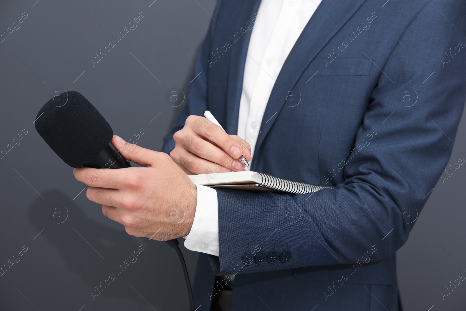 Photo of Professional journalist taking notes on dark background, closeup