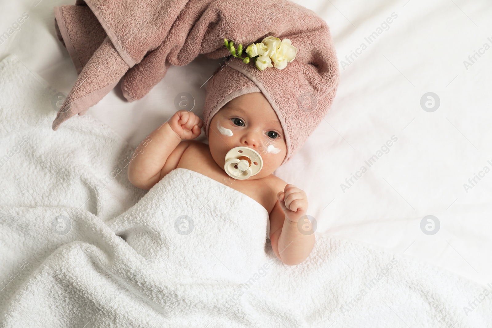 Photo of Cute little baby with cream on face, top view