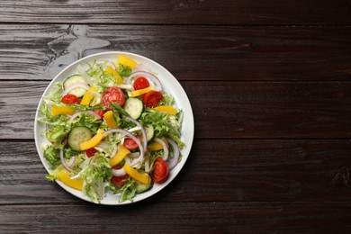 Tasty fresh vegetarian salad on dark wooden table, top view. Space for text