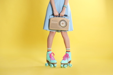 Young woman with roller skates and retro radio on color background, closeup