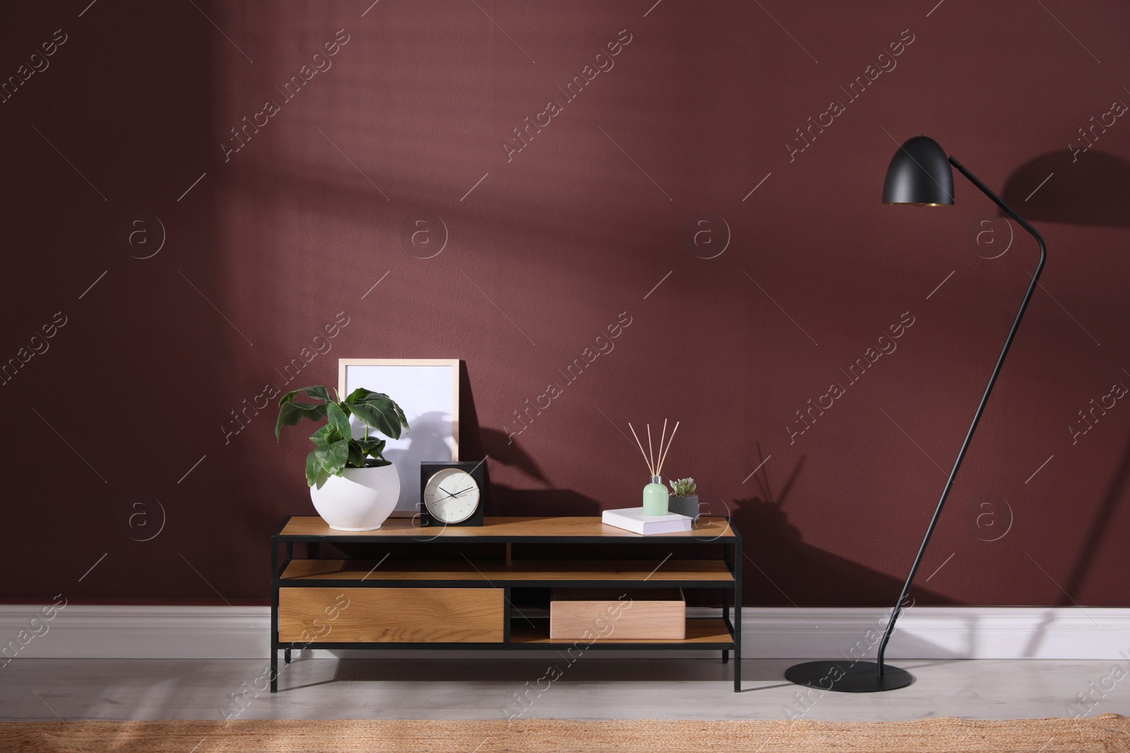 Photo of Elegant room interior with wooden cabinet and floor lamp near brown wall