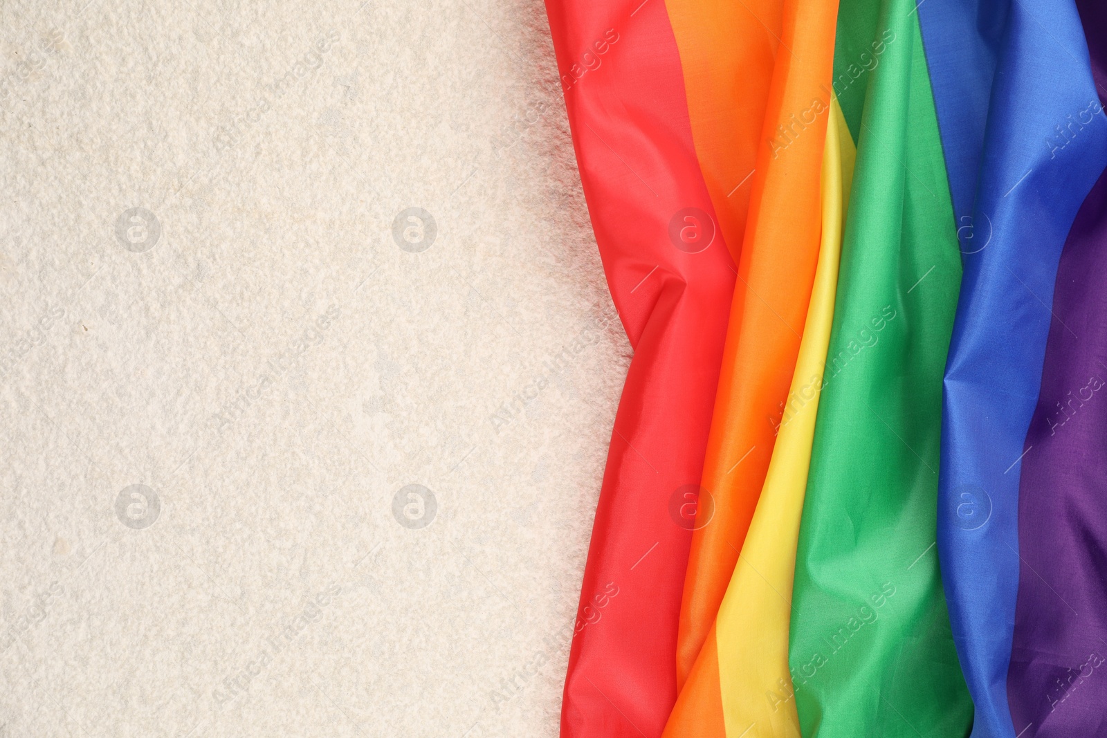 Photo of Rainbow LGBT flag on white background, top view. Space for text