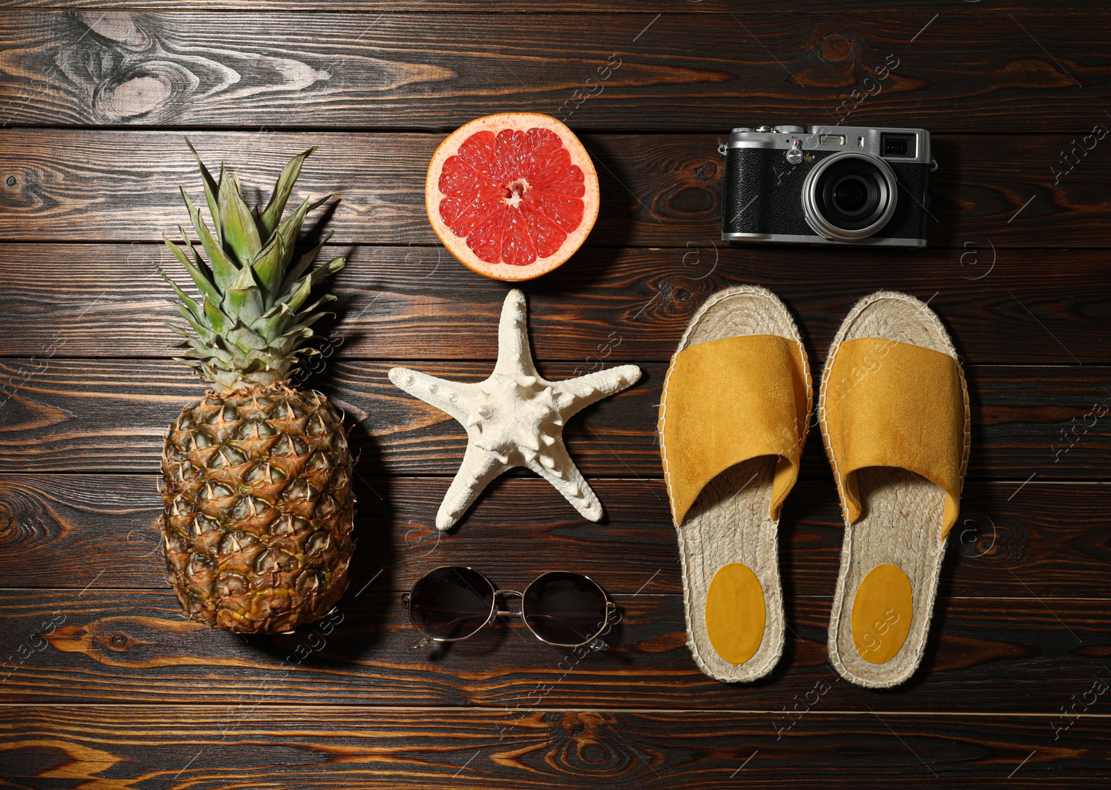 Photo of Flat lay composition with vintage camera and beach objects on wooden background