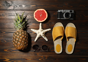 Flat lay composition with vintage camera and beach objects on wooden background