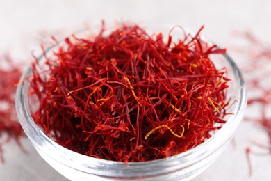 Dried saffron in glass bowl on table, closeup