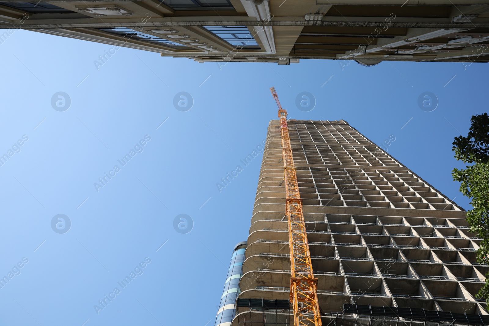 Photo of Modern unfinished multistory building against blue sky, low angle view