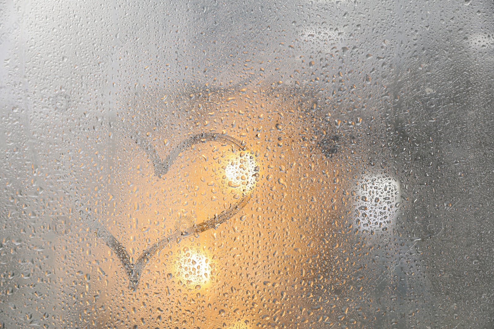 Photo of Heart drawn on foggy window. Rainy weather