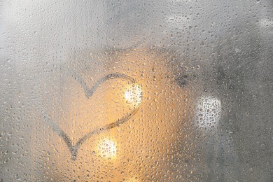 Photo of Heart drawn on foggy window. Rainy weather