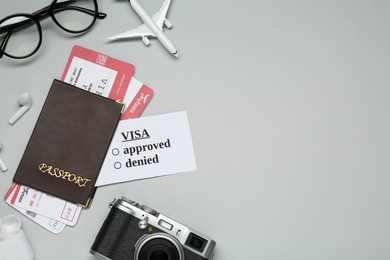 Photo of Flat lay composition with passport, toy plane and tickets on light grey background, space for text. Visa receiving