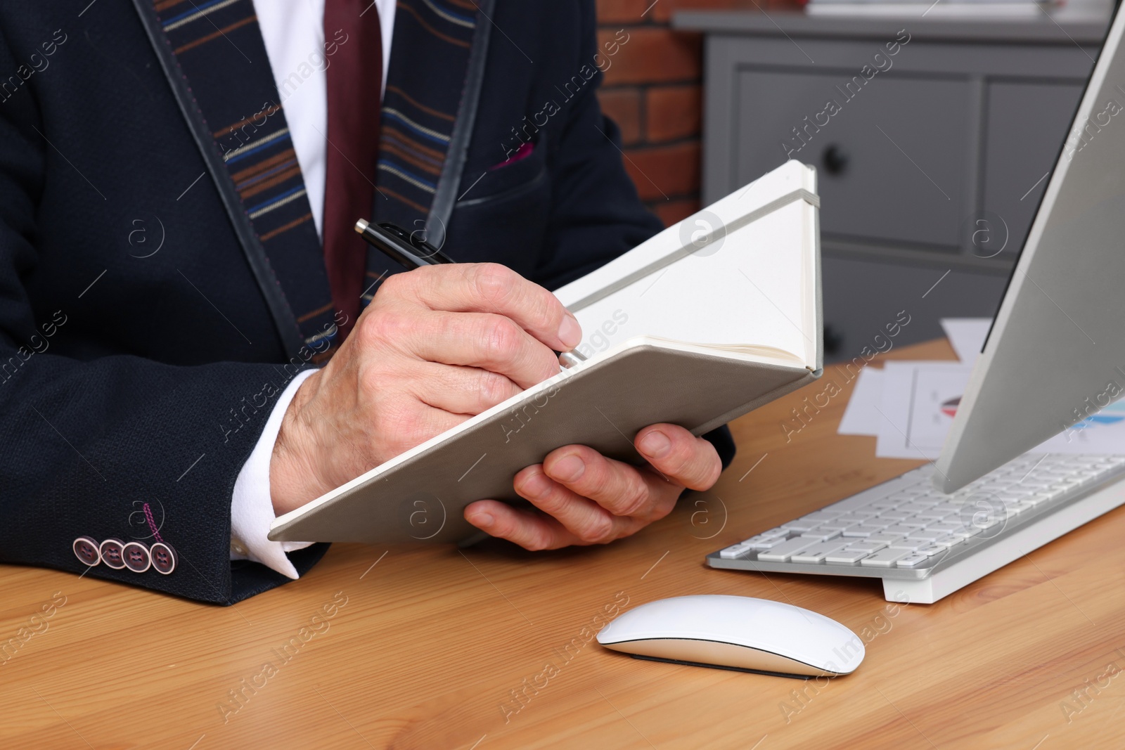 Photo of Boss working at wooden table indoors, closeup