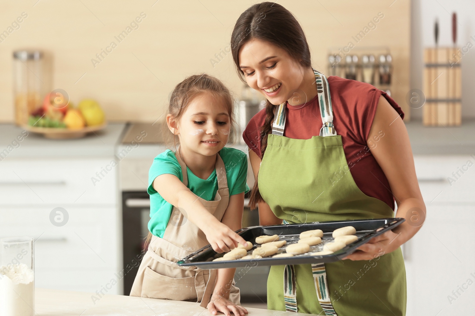 Photo of Mother and her daughter with cookie dough in kitchen