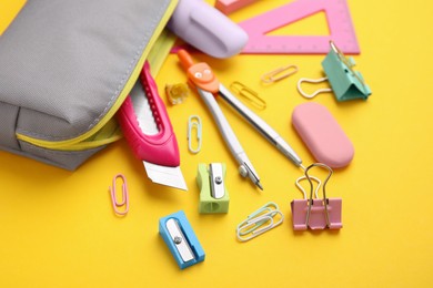 Photo of Many different school stationery on yellow background. Back to school