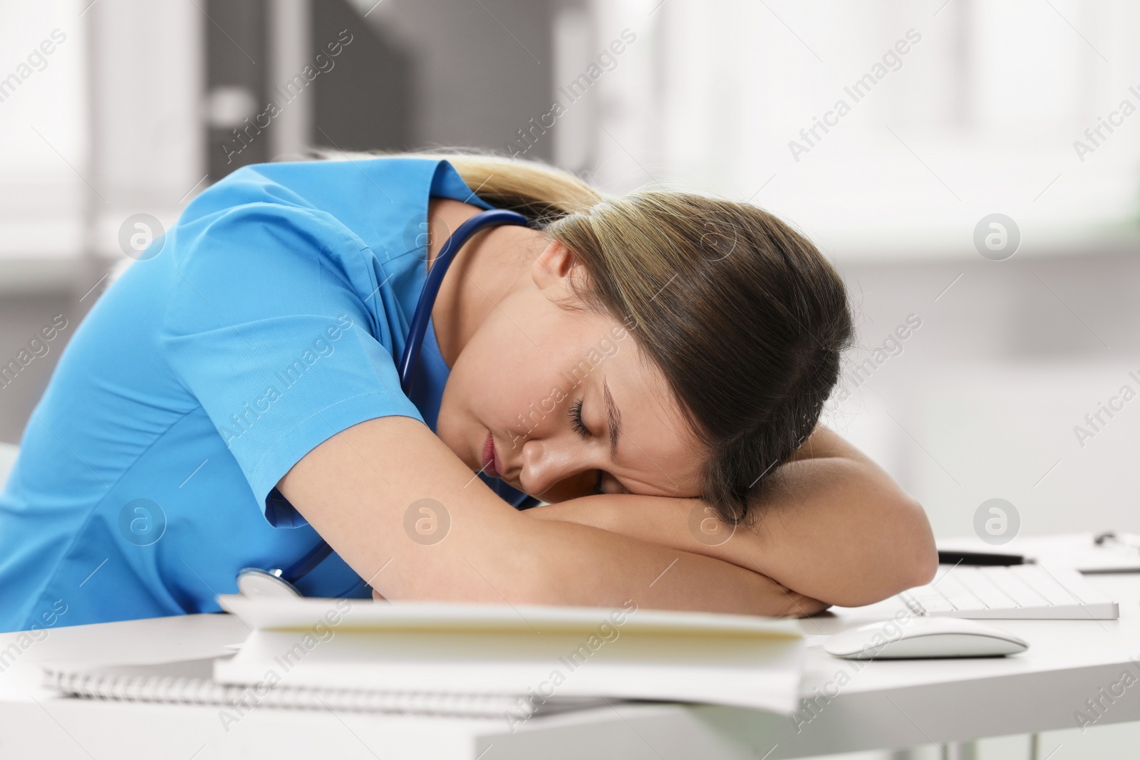 Photo of Exhausted doctor sleeping at workplace in hospital