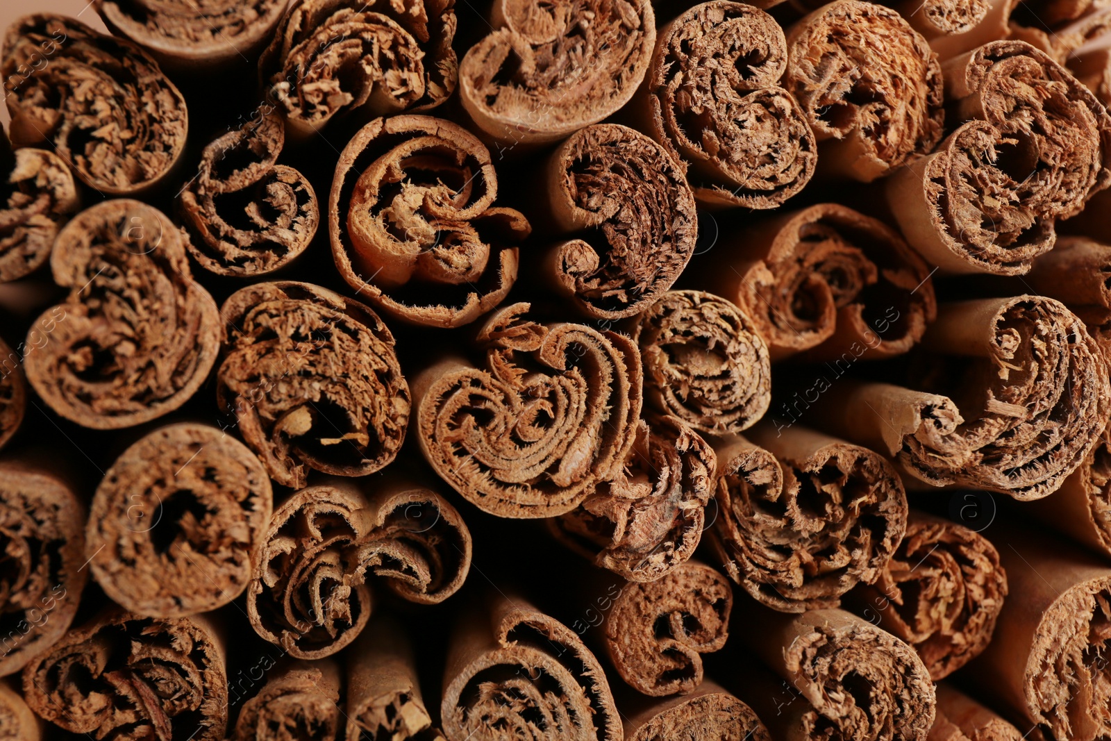 Photo of Aromatic cinnamon sticks as background, top view