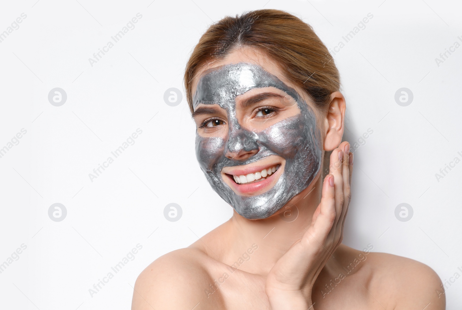 Photo of Beautiful woman with mask on face against light background