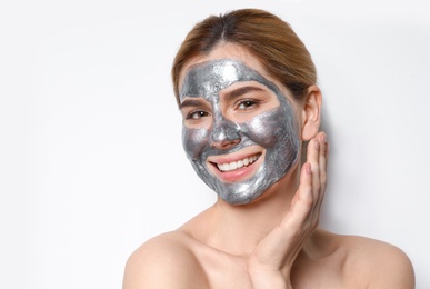 Photo of Beautiful woman with mask on face against light background