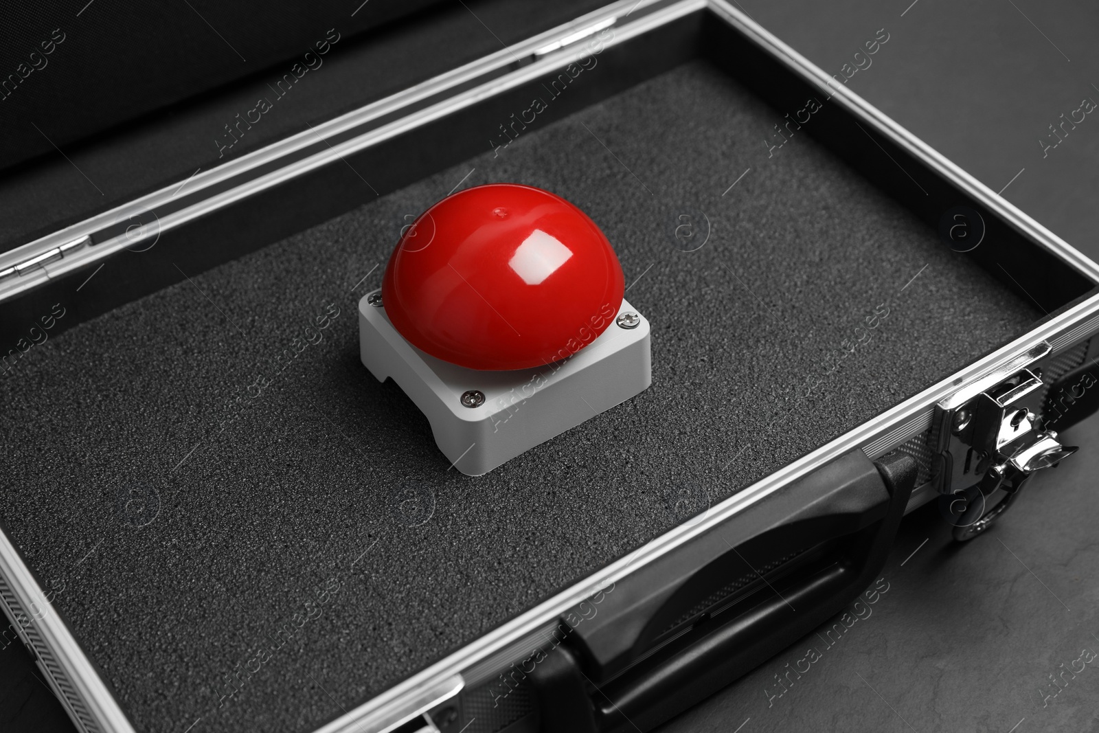 Photo of Red button of nuclear weapon in suitcase on black background. War concept