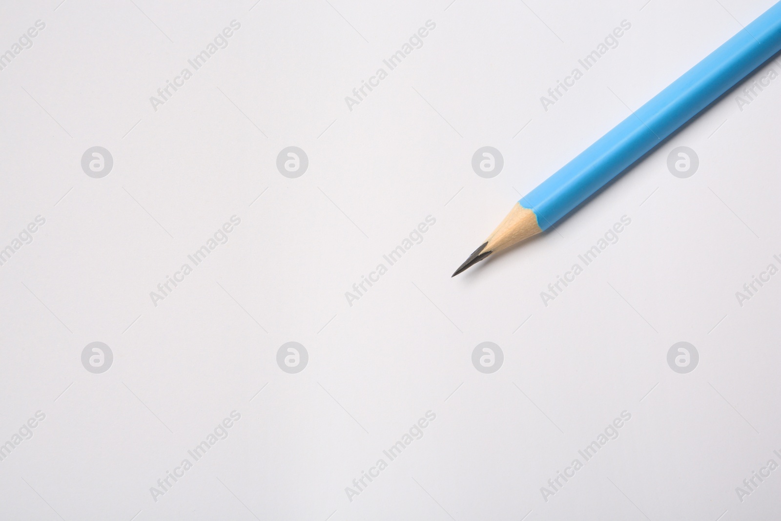 Photo of Sharp graphite pencil on white background, top view. Space for text