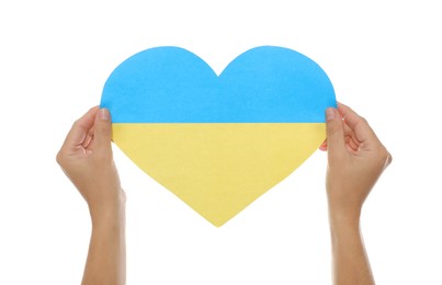 Woman holding paper heart in colors of Ukrainian flag on white background, closeup