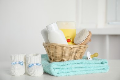 Photo of Baby booties and accessories on white table indoors