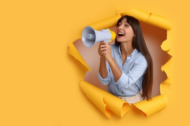 Special promotion. Woman with megaphone shouting through hole in orange paper. Space for text