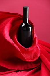 Photo of Stylish presentation of delicious red wine in bottle on pink background